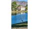 Waterfront house with a lush lawn and mature trees reflected in the tranquil lake in the background at 4093 E Westchester Dr, Chandler, AZ 85249