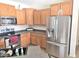 Well-lit kitchen featuring stainless steel appliances, wood cabinets and dark countertops, providing style and functionality at 44583 W Sandstone Dr, Maricopa, AZ 85139