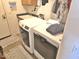 Functional laundry room with white washer and dryer, a sink, and neutral decor with door to the outside at 44583 W Sandstone Dr, Maricopa, AZ 85139
