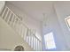 Bright stairway featuring light walls, a white railing, and modern decor in a home with vaulted ceilings and abundant natural light at 44583 W Sandstone Dr, Maricopa, AZ 85139