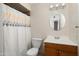 This bathroom features a vanity with a wood cabinet, a toilet, and a shower with a decorative shower curtain at 5227 W Acapulco Ln, Glendale, AZ 85306