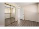 This bedroom features wood floors, neutral walls, a mirrored closet, and ample natural light at 5227 W Acapulco Ln, Glendale, AZ 85306
