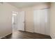 This bedroom features wood floors, neutral walls, and a closet with sliding doors at 5227 W Acapulco Ln, Glendale, AZ 85306