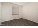 This bedroom features wood floors, neutral walls, and a window with blinds at 5227 W Acapulco Ln, Glendale, AZ 85306