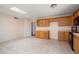 Open kitchen with tile floors, wood cabinetry and bright overhead lighting at 5227 W Acapulco Ln, Glendale, AZ 85306