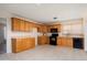 Classic kitchen with wood cabinetry, light countertops, and black appliances at 5227 W Acapulco Ln, Glendale, AZ 85306