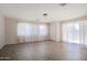 Spacious living room showcasing wood-look floors, neutral walls, large windows with curtains and sliding door at 5227 W Acapulco Ln, Glendale, AZ 85306