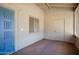 Covered porch with neutral walls and floors and a vibrant blue door at 5227 W Acapulco Ln, Glendale, AZ 85306