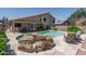 A beautiful backyard features a pool with rock waterfall, patio and mature landscaping at 5596 W Mercer Ln, Glendale, AZ 85304