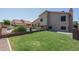 The backyard features a pool with a waterfall, green grass, and a covered patio at 5596 W Mercer Ln, Glendale, AZ 85304