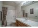Neutral bathroom with white tile, vanity, framed mirror, and coordinated shower curtain at 5596 W Mercer Ln, Glendale, AZ 85304
