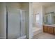 Clean bathroom featuring a walk-in shower, large soaking tub, and vanity sink at 5596 W Mercer Ln, Glendale, AZ 85304