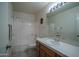 Neutral bathroom with white tile, a vanity, framed mirror, and coordinated shower curtain at 5596 W Mercer Ln, Glendale, AZ 85304