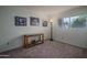 Bright bedroom with light-colored carpet, a window, a lamp, and pictures on the wall at 5596 W Mercer Ln, Glendale, AZ 85304