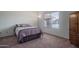 Image of a bedroom with carpet, full size bed, and window overlooking front yard at 5596 W Mercer Ln, Glendale, AZ 85304