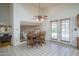 Bright dining area features white tiled floors, wooden table with chairs and ceiling fan, plus access to the pool through glass doors at 5596 W Mercer Ln, Glendale, AZ 85304