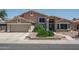 Charming two-story home with a tile roof, a lush green lawn, and a multi car garage at 5596 W Mercer Ln, Glendale, AZ 85304