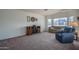 Spacious living room featuring a cozy fireplace, neutral carpet, and large windows at 5596 W Mercer Ln, Glendale, AZ 85304