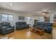 Bright living room with hardwood floors and comfortable gray leather sofas at 5596 W Mercer Ln, Glendale, AZ 85304