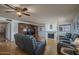 View of the living room with fireplace, hardwood floors, TV, wooden cabinet and gray leather sofas at 5596 W Mercer Ln, Glendale, AZ 85304