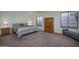 The main bedroom features neutral carpet, generous windows, bedside tables, and an armoire at 5596 W Mercer Ln, Glendale, AZ 85304