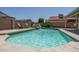 Backyard pool with a rock waterfall, seating area, and view of surrounding houses at 5596 W Mercer Ln, Glendale, AZ 85304