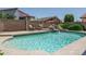 Picture of the backyard pool with chairs, lush greenery and rock waterfall feature at 5596 W Mercer Ln, Glendale, AZ 85304