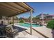 Backyard pool features rock waterfall, mature banana trees, and covered patio at 5596 W Mercer Ln, Glendale, AZ 85304