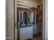View inside walk-in closet with hanging clothes and built-in shelves and drawers at 5596 W Mercer Ln, Glendale, AZ 85304