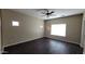 Bedroom featuring dark floors, a ceiling fan, and a bright window at 6908 S 54Th Ln, Laveen, AZ 85339