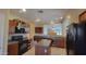 Open kitchen with island, wood cabinets and black appliances at 6908 S 54Th Ln, Laveen, AZ 85339