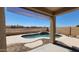 View of the backyard pool and a desert landscape from the covered patio at 6908 S 54Th Ln, Laveen, AZ 85339