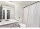 Bathroom with a gray vanity, white walls, and a shower with white curtain at 7310 N 68Th Ln, Glendale, AZ 85303