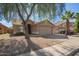 Traditional single-story home with a two-car garage, desert landscaping, and a mature shade tree in the front yard at 7310 N 68Th Ln, Glendale, AZ 85303