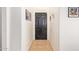 Narrow hallway with tiled floor and a black door at the end at 7310 N 68Th Ln, Glendale, AZ 85303