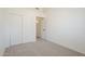 A bedroom with neutral carpet, white walls, closet and a glimpse into another room at 8541 W Sierra Vista Dr, Glendale, AZ 85305