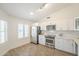 The bright kitchen has white cabinets, stainless appliances, subway tile backsplash, and wood-look tile flooring at 8541 W Sierra Vista Dr, Glendale, AZ 85305