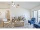 Spacious, bright living room features a ceiling fan, wood-look tile flooring, and a contemporary rug at 8541 W Sierra Vista Dr, Glendale, AZ 85305