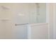 Bright white bathroom with a stand-up shower, shelving, and grab bar at 8541 W Sierra Vista Dr, Glendale, AZ 85305