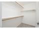 An organized walk-in closet featuring white walls, shelves and rod with carpeted flooring at 8541 W Sierra Vista Dr, Glendale, AZ 85305