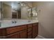 Bathroom vanity featuring double sinks, tile backsplash, and wood cabinetry, offering ample storage at 8964 W Northview Ave, Glendale, AZ 85305