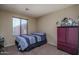 Bedroom with a modern bed, neutral paint, carpet flooring, a window with blinds, and a decorative cabinet at 8964 W Northview Ave, Glendale, AZ 85305