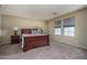 Bright bedroom featuring a dark wood bed frame, neutral walls, and carpeted floors, creating a cozy and inviting atmosphere at 8964 W Northview Ave, Glendale, AZ 85305