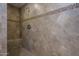 Walk-in shower featuring decorative tile detail, a built-in seat, and tiled walls at 8964 W Northview Ave, Glendale, AZ 85305