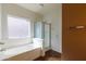 A serene bathtub with a frosted glass window offers a peaceful bathing experience at 909 E Harwell Rd, Phoenix, AZ 85042