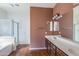 Bathroom featuring a double sink vanity, soaking tub, and glass-enclosed shower at 909 E Harwell Rd, Phoenix, AZ 85042