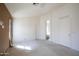 Spacious bedroom featuring neutral carpet, white walls, and natural light from nearby bathroom at 909 E Harwell Rd, Phoenix, AZ 85042