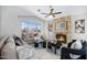 Bright living room with a stone fireplace, comfortable seating, and a large window with neighborhood views at 10214 E Moonshadow Way, Gold Canyon, AZ 85118