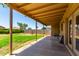 Covered back patio with spacious backyard featuring green grass and block fence, perfect for outdoor living at 10521 W Donald Dr, Peoria, AZ 85383