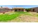 Expansive backyard featuring green grass, desert landscaping and a covered patio, providing ample space for entertainment at 10521 W Donald Dr, Peoria, AZ 85383